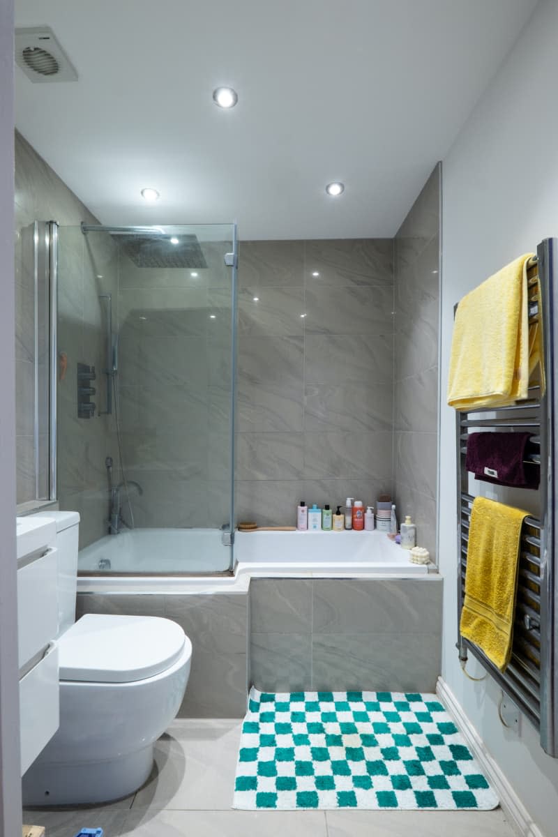 View of large tub in bathroom with gray tile.