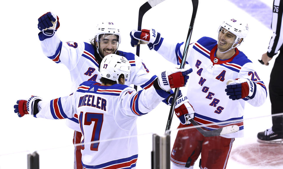 New York Rangers right wing Blake Wheeler (17) celebrates with Mika Zibanejad (93) and Chris Kreider (20) after scoring against the New Jersey Devils during the third period of an NHL hockey game Saturday, Nov. 18, 2023, in Newark, N.J. (AP Photo/Noah K. Murray)