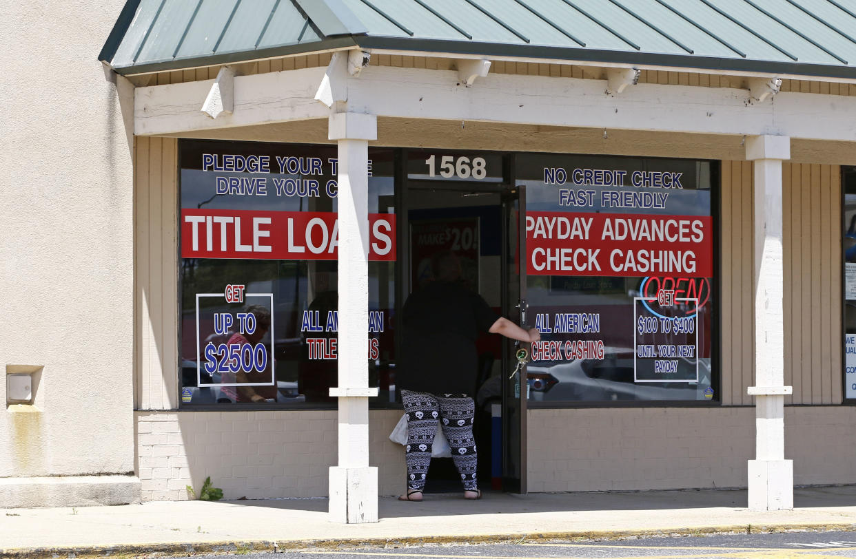 A woman enters an All American Check Cashing location in Brandon, Miss., Friday, May 12, 2017. (AP Photo/Rogelio V. Solis)