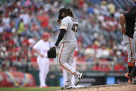 San Francisco Giants starting pitcher Johnny Cueto, center, walks to the dugout after he was pulled during the sixth inning of a baseball game against the Washington Nationals, Sunday, June 13, 2021, in Washington. (AP Photo/Nick Wass)