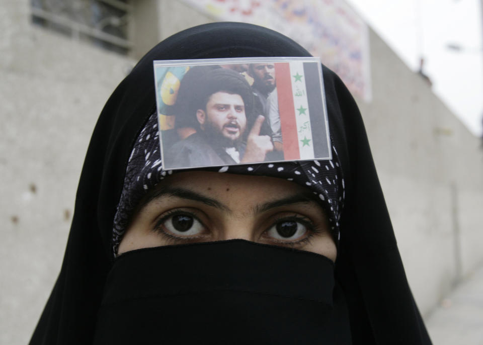 FILE - A Shiite woman, with a picture of radical cleric Muqtada al-Sadr on her veil, is seen during a protest in Sadr City, Baghdad, Iraq, Thursday, March 27, 2008. Al-Sadr is a populist cleric, who emerged as a symbol of resistance against the U.S. occupation of Iraq after the 2003 invasion. (AP Photo/Karim Kadim, File)
