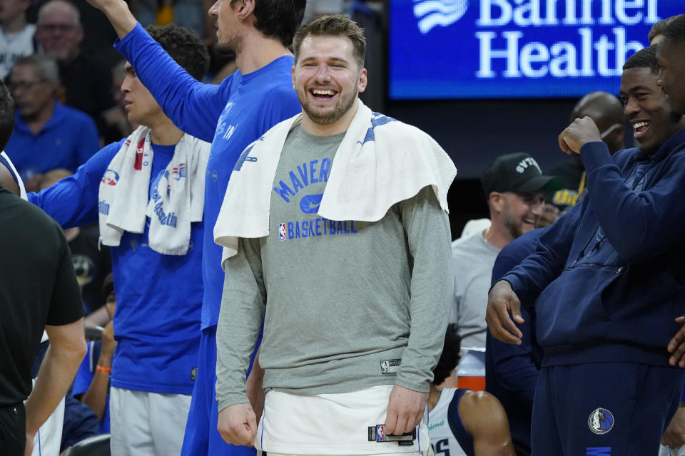 Dallas Mavericks guard Luka Doncic smiles on the bench during the second half of Game 7 of an NBA basketball Western Conference playoff semifinal against the Phoenix Suns, Sunday, May 15, 2022, in Phoenix. The Mavericks defeated the Suns 123-90. (AP Photo/Matt York)