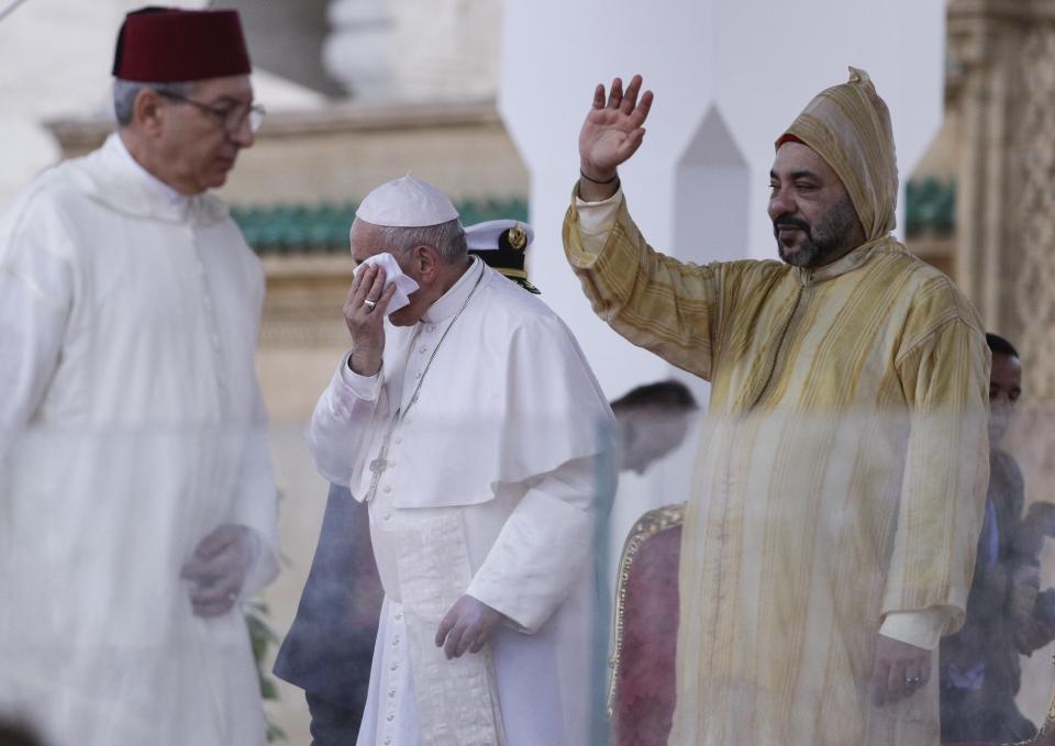 Moroccan King Mohammed VI waves as Pope Francis wipes his forehead, in Rabat, Morocco, Saturday, March 30, 2019. Francis's weekend trip to Morocco aims to highlight the North African nation's tradition of Christian-Muslim ties while also letting him show solidarity with migrants at Europe's door and tend to a tiny Catholic flock on the peripheries. (AP Photo/Gregorio Borgia)