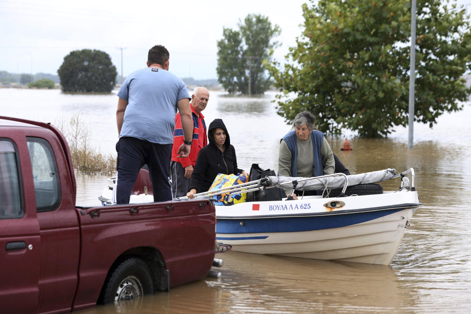 Local residents use a small boat during an evacuee operation from the village of Farkadona, Thessaly region, central Greece, Thursday, Sept. 7, 2023. Greece's fire department says more than 800 people have been rescued over the past two days from floodwaters, after severe rainstorms turned streets into raging torrents, hurling cars into the sea and washing away roads. (AP Photo/Vaggelis Kousioras)
