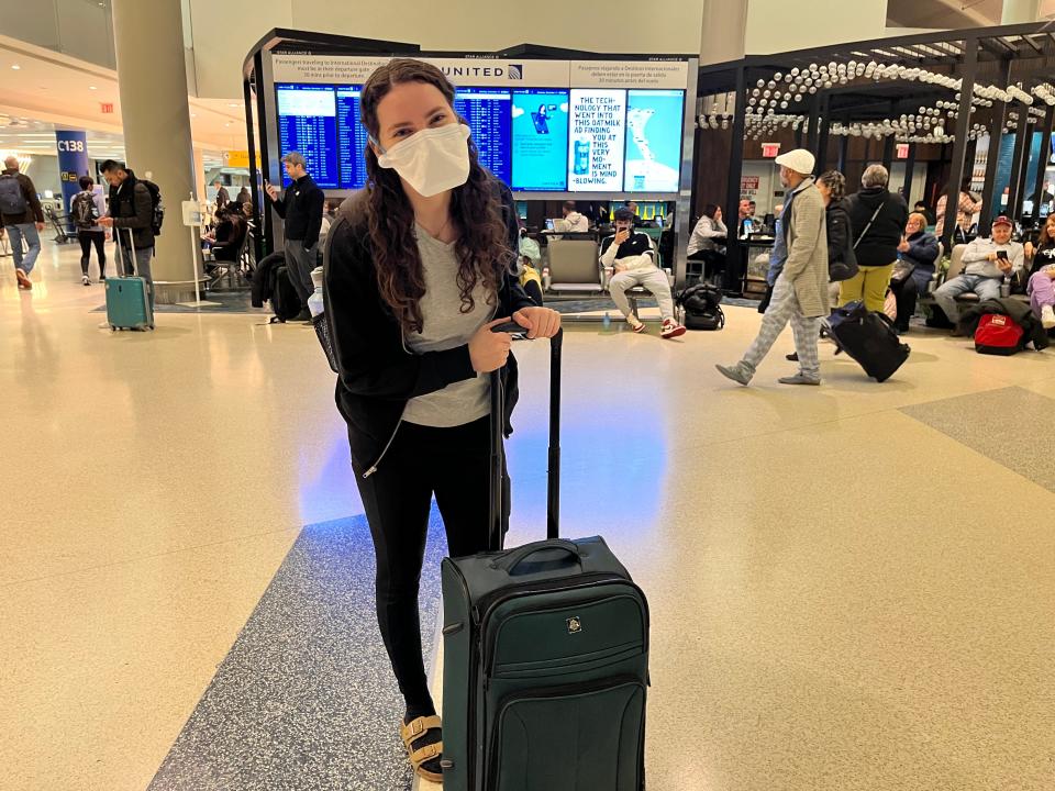 Talia Lakritz holds a suitcase in an airport terminal.