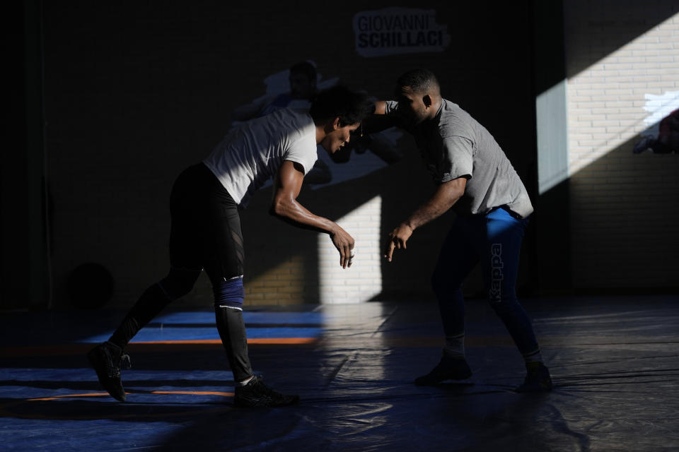 Guinean wrestler Fatoumata Yarie Camara, left, compete with Wilfredo Garcia, trainer of the Italian female wrestling team during an afternoon training session in Ostia, near Rome, Monday, July 5, 2021. A West African wrestler's dream of competing in the Olympics has come down to a plane ticket. Fatoumata Yarie Camara is the only Guinean athlete to qualify for these Games. She was ready for Tokyo, but confusion over travel reigned for weeks. The 25-year-old and her family can't afford it. Guinean officials promised a ticket, but at the last minute announced a withdrawal from the Olympics over COVID-19 concerns. Under international pressure, Guinea reversed its decision. (AP Photo/Alessandra Tarantino)