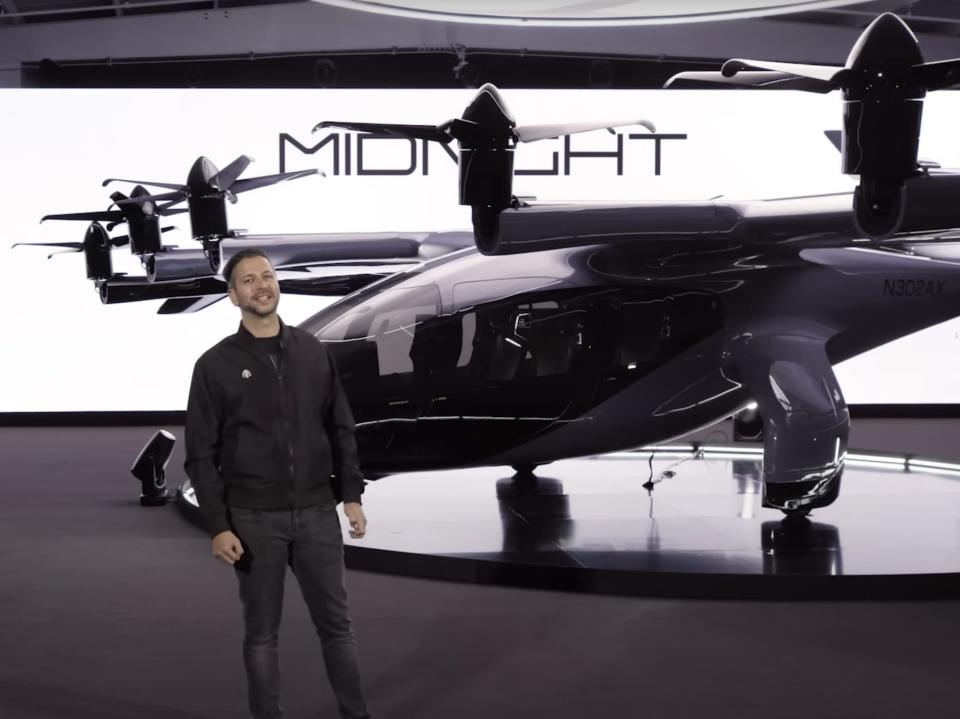 Adam Goldstein in front of the black Midnight eVTOL at November's unveiling.