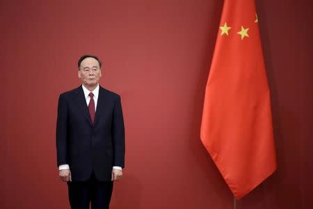 FILE PHOTO: China's Politburo Standing Committee member Wang Qishan stands next to a Chinese flag at the Great Hall of the People in Beijing, China, September 2, 2015. REUTERS/Jason Lee/File Photo