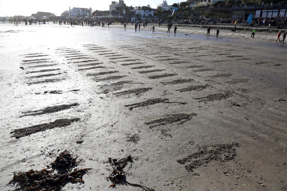 <p>Dozens of figures were also etched into the sand in Lyme Regis to commemorated those who lost their lives. (SWNS) </p>