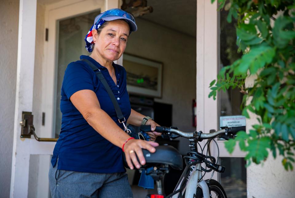 Laura Sanchez, 53, poses for a photo with her bike Wednesday at Church of St. Paul In the Desert in Palm Springs.