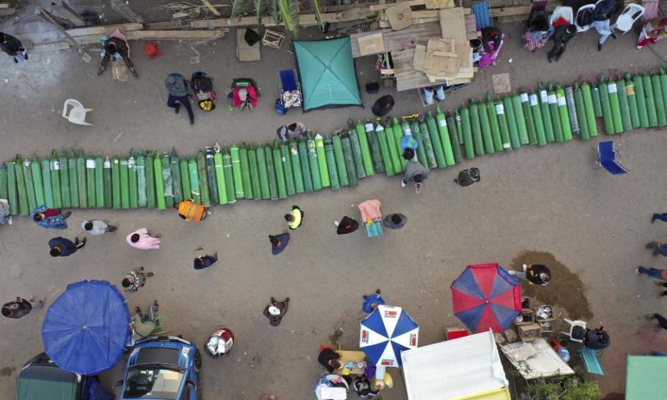 People line up their empty oxygen tanks outside of a shop while waiting for refills as Lima, Peru, suffers a shortage of medical oxygen.