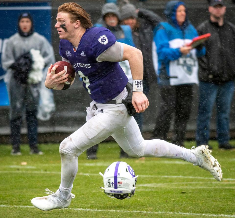 Holy Cross quarterback Matthew Sluka loses his helmet on his way to the end zone against University of New Hampshire Saturday, December 3, 2022. The touchdown did not count as penalties were called on the play.