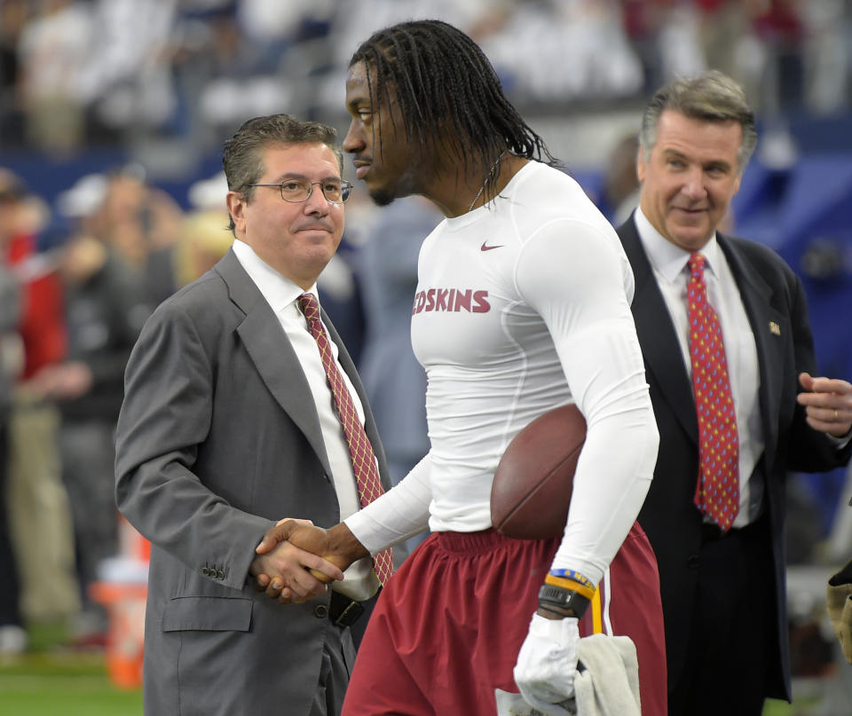 Dan Snyder, left, shakes hand with Washington quarterback Robert Griffin III (10), center, during warm-ups, as team president Bruce Allen looks on before the Washington Redskins play the Dallas Cowboys in Arlington TX, January 3, 2016. (Photo by John McDonnell / The Washington Post via Getty Images)