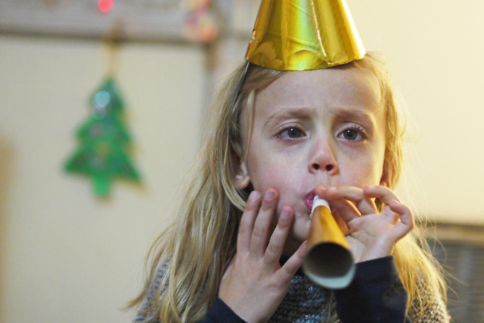 A little girl blowing a noise-maker