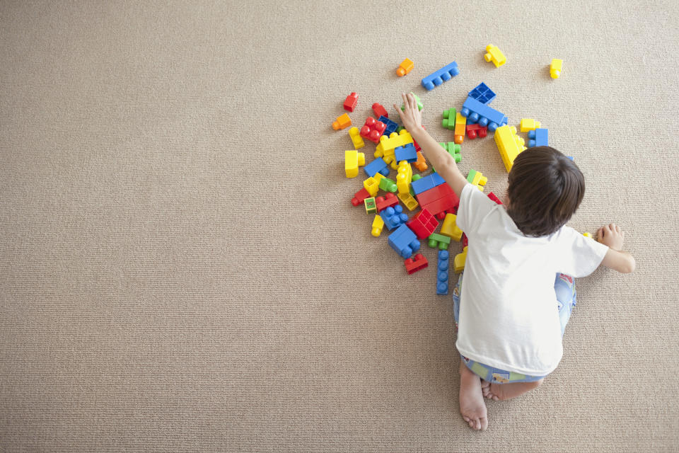 boy playing with blocks on the floor, from above