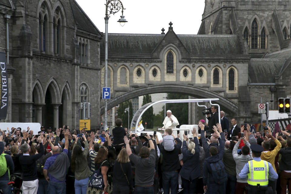 Pope Francis waves to the waiting crowds on Christchurch, Dublin as he travels in the Popemobile during his visit to Ireland, Saturday, Aug. 25, 2018. (Brian Lawless/PA via AP)