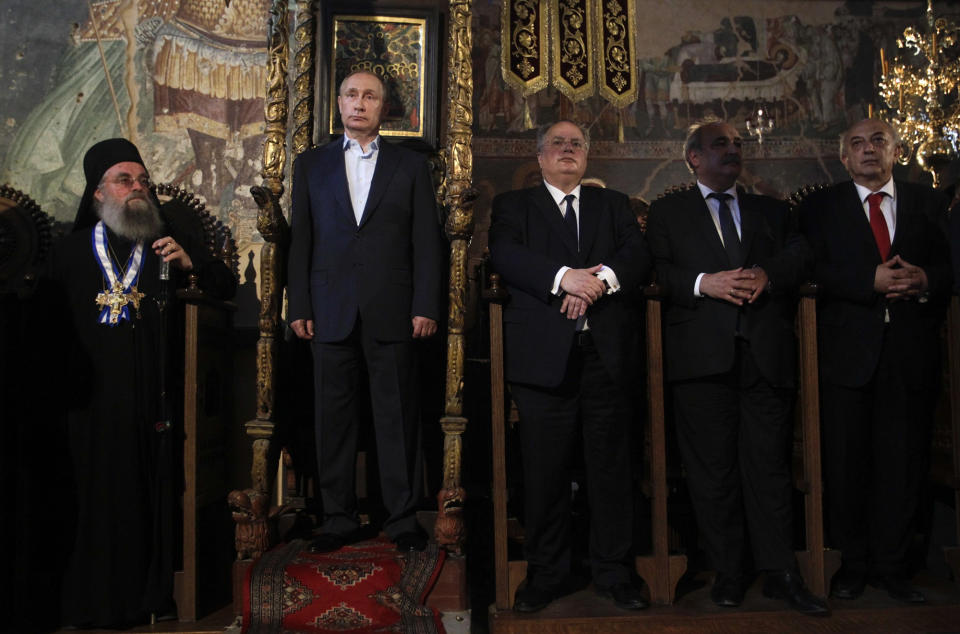 <p>Russian President Vladimir Putin, second left, and Greek Foreign Minister Nikos Kotzia, center, visit the church of the Protaton, dedicated to the Dormition of the Virgin, in Karyes, the administrative center of the all-male Orthodox monastic community of Mount Athos, northern Greece, May 28, 2016. Putin has arrived at the northern Greek peninsula of Mount Athos, on a visit to the autonomous Orthodox Christian monastic community. (Alexandros Avramidis/Pool Photo via AP) </p>