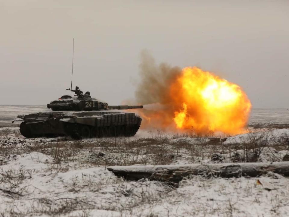 A Russian tank T-72B3 fires as troops take part in drills at the Kadamovskiy firing range in the Rostov region in southern Russia on Wednesday. Russia has rejected Western complaints about its troop buildup near Ukraine, saying it deploys them wherever it deems necessary on its own territory. (The Associated Press - image credit)