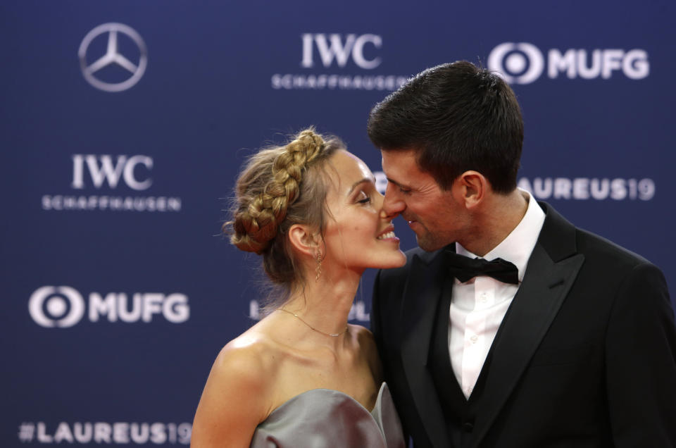 FILE - Serbian tennis player Novak Djokovic and his wife Jelena kiss as they arrive for the 2019 Laureus World Sports Awards, Feb. 18, 2019. The 34-year-old Serb and his wife, Jelena, share new age, esoteric beliefs and together have visited the Bosnian hill town of Visoko, where some believe that four hills shaped like pyramids offer healing powers, a claim disputed by scientists. (AP Photo/Claude Paris, File)