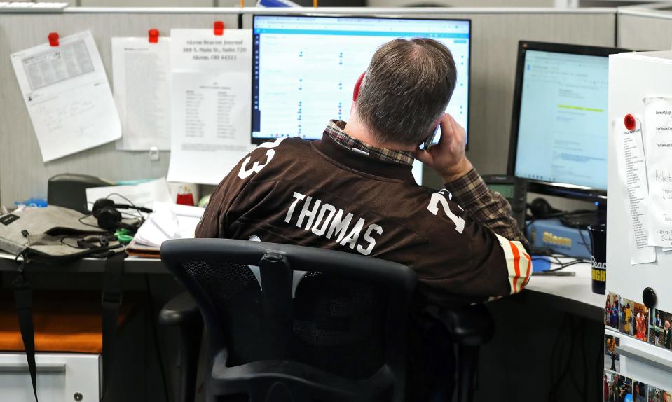 Beacon Journal Metro Editor Joe Thomas, not to be confused with the former left tackle for the Cleveland Browns makes a phone call during his workday Tuesday.