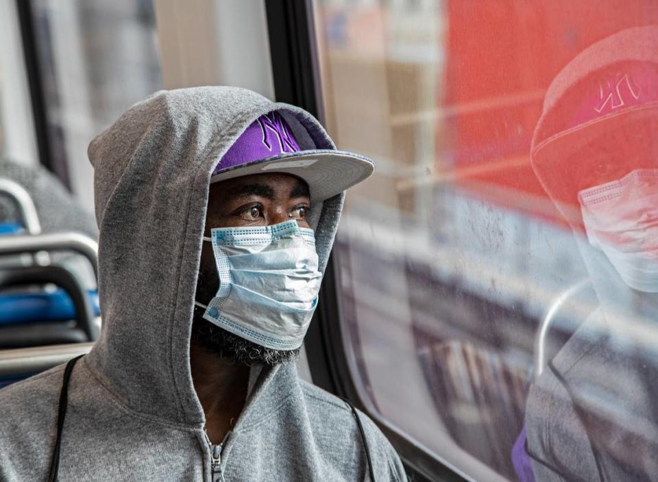 Jim Cantave looks on while riding the Metrorail wearing a protective mask during the COVID19 pandemic in Miami on Wednesday, April 1, 2020.