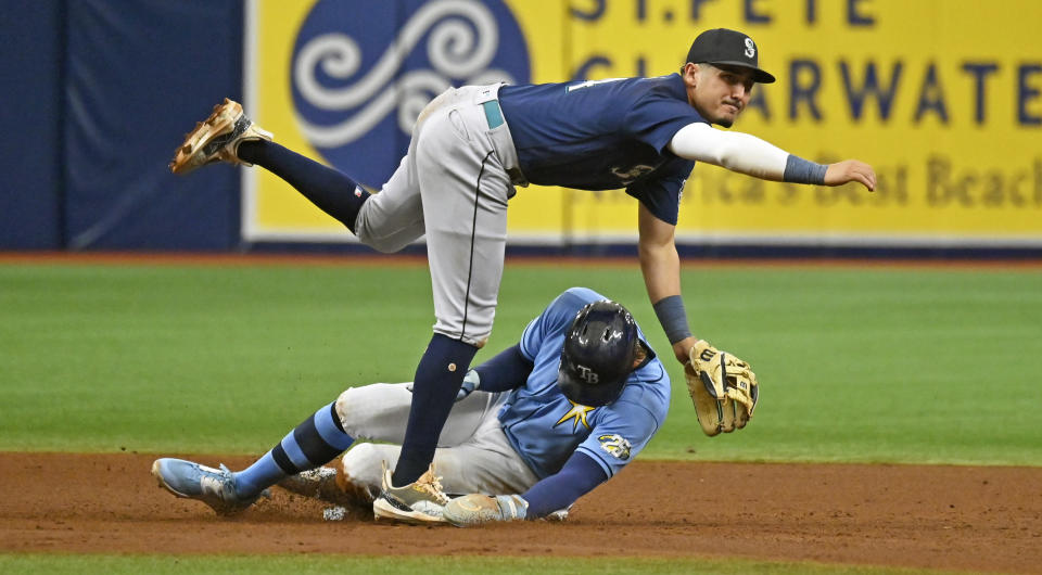 Seattle Mariners' Josh Rojas, top, watches his throw to first base to complete a double play after forcing out Tampa Bay Rays' Josh Lowe, bottom, at second base during the fifth inning of a baseball game Sunday, Sept. 10, 2023, in St. Petersburg, Fla. (AP Photo/Steve Nesius)