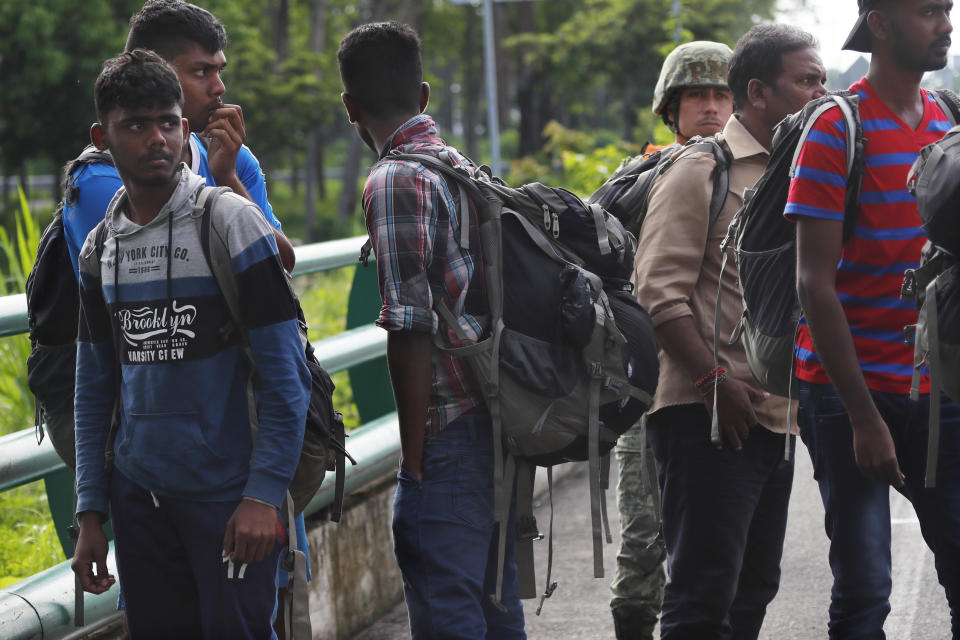 Migrants from India are detained by Mexican immigration officials at a checkpoint where soldiers are stationed on the highway in Tapachula, Chiapas state, Mexico, June 10, 2019.  Mexican and U.S. officials reached an accord late Friday that calls on Mexico to crackdown on migrants in exchange for Trump backing off his threat to impose a 5% tariff on Mexico’s exports. (AP Photo/Marco Ugarte)