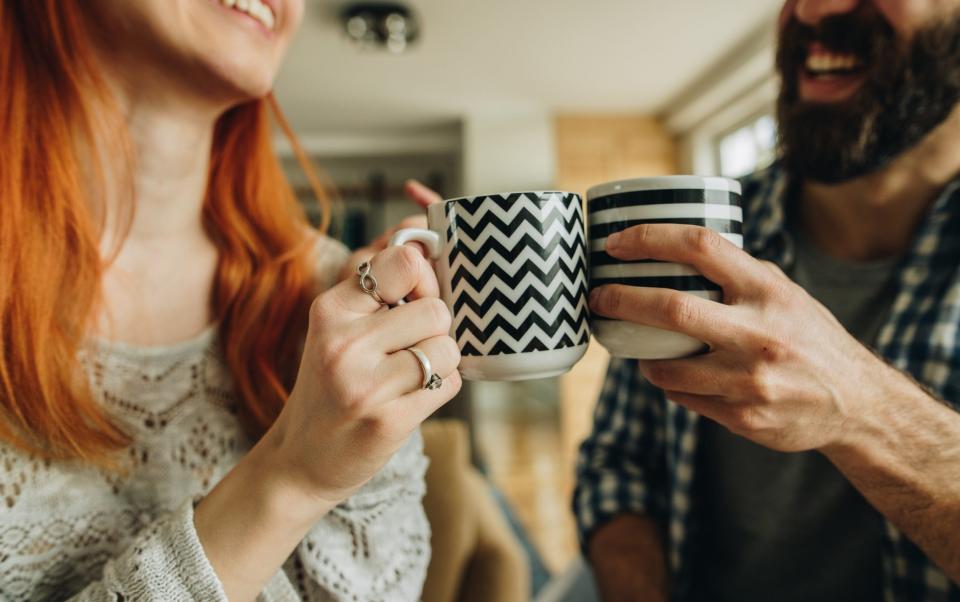 happy couple toasting with mugs - skynesher