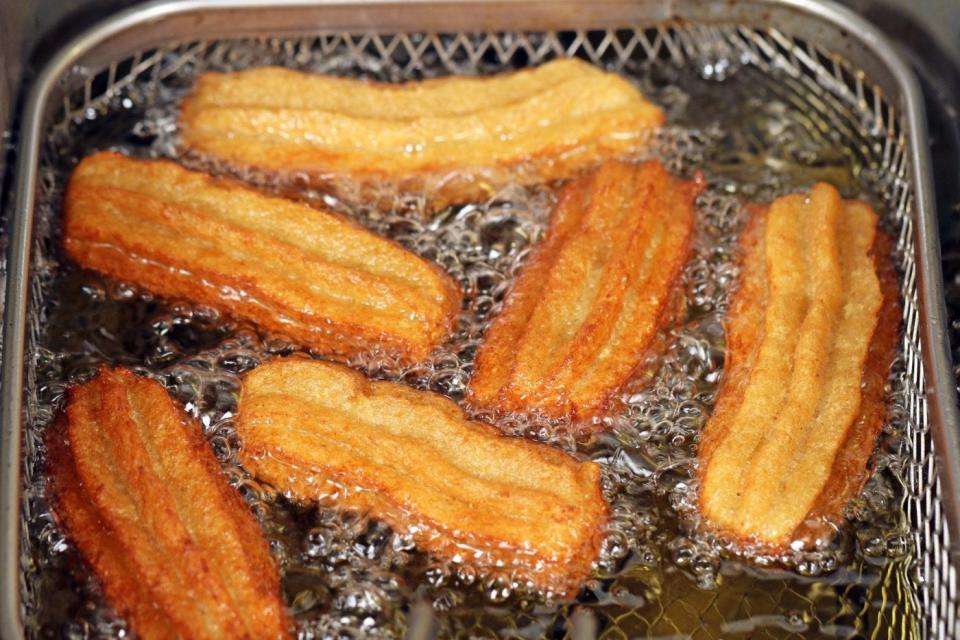 Frying churros in oil.