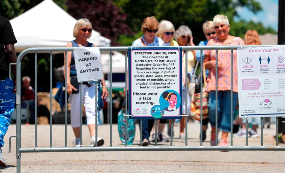 The sign for Executive Order 147 from June 2020, requiring face masks in public when social distancing is not possible, is still displayed at The Raleigh Market at the N.C. State Fairgrounds in Raleigh, N.C., Saturday, May 15, 2021. Gov. Roy Cooper said Friday that it’s now safe for people to move around in public without wearing a mask.