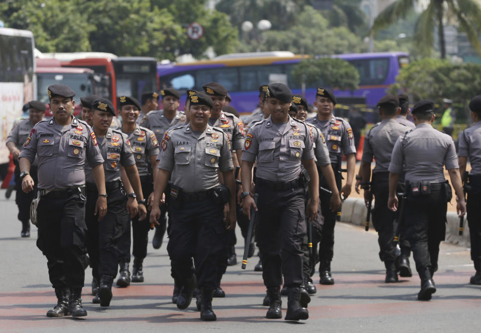 Indonesian police walk in Jakarta, Indonesia, Tuesday, May 21, 2019. Indonesia's President Joko Widodo has been elected for a second term, official results showed Tuesday, in a victory over a would-be strongman who aligned himself with Islamic hardliners. Thousands of police and soldiers are on high alert in the capital Jakarta, anticipating protests from Widodo's challenger Prabowo Subianto's supporters. (AP Photo/Achmad Ibrahim)