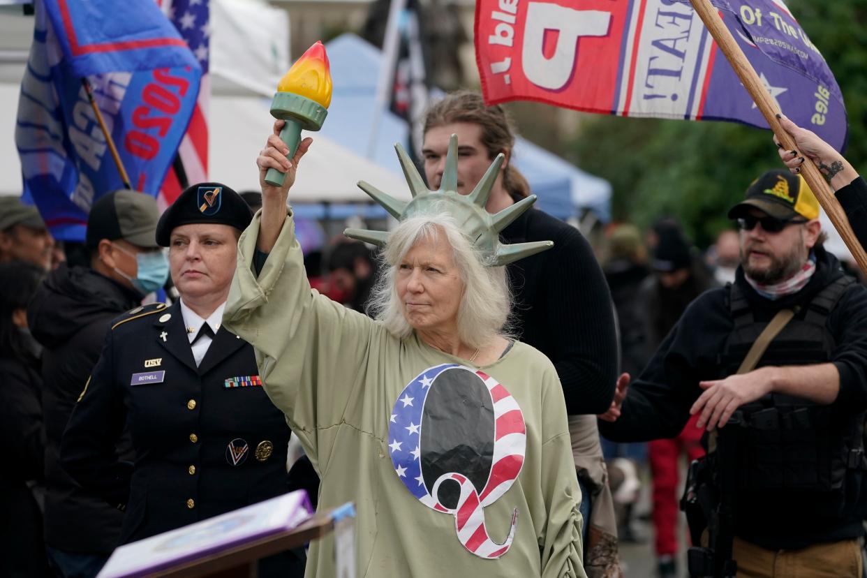 <p>A person dressed as Lady Liberty wears a shirt with the letter Q, referring to QAnon, as protesters take part in a protest, Wednesday, Jan. 6, 2021</p> (AP)