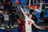 FILE - Florida forward Colin Castleton (12) blocks the shot of Virginia Tech guard Tyrece Radford (23) in the second half of a first round game in the NCAA men's college basketball tournament at Hinkle Fieldhouse in Indianapolis, in this Friday, March 19, 2021, file photo. Florida added three defensive stalwarts via the NCAA transfer portal, led by two-time Big South defensive player of the year Phlandrous Fleming and Summit League defensive player of the year Brandon McKissic. Throw in returning shot-blocker Colin Castleton and Boston College transfer CJ Felder, and the Gators have – at least on paper – their best collection of defenders since Scottie Wilbekin, Casey Prather, Will Yeguete and Patric Young ran roughshod through the league in 2014 and advanced to the Final Four. (AP Photo/Michael Conroy, File)