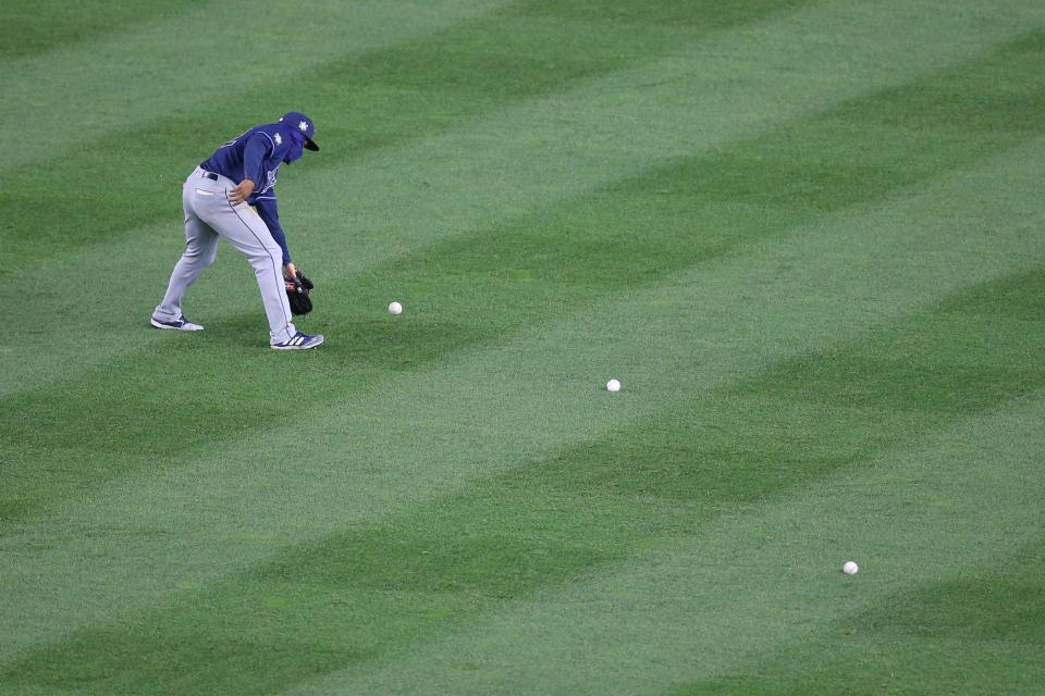 Tampa Bay Rays left fielder Randy Arozarena picks up baseballs thrown onto the field by fans during the eighth inning against the New York Yankees at Yankee Stadium.