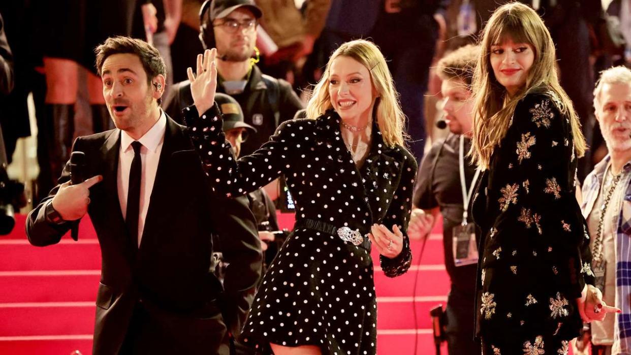 French TV and radio host Camille Combal (L), flanked by Belgian singer and music composer Angele van Laeken, aka Angele (C) and French singer and music composer Clara Luciani (2ndR), gestures upon his arrival to attend the 24th edition of the NRJ Music Awards ceremony at the Palais des Festivals in Cannes, southeastern France, on November 18, 2022. (Photo by Valery HACHE / AFP) (Photo by VALERY HACHE/AFP via Getty Images)