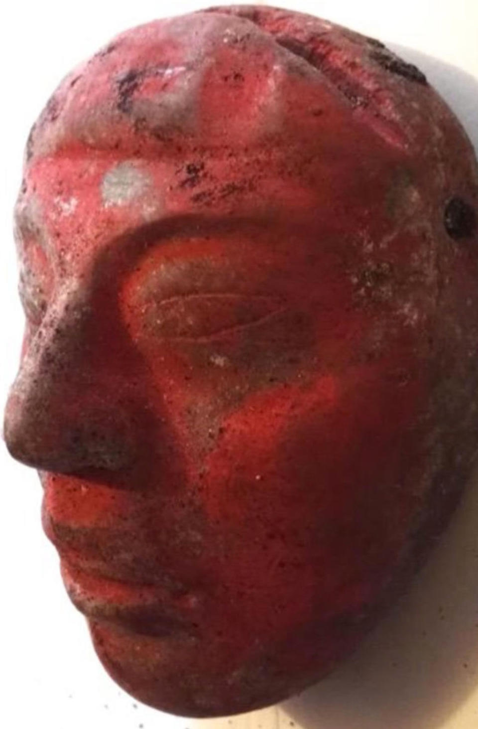 A jade mask painted red with cinnabar was found in the tomb of the Maya ruler. <cite>Courtesy of Proyecto Arqueológico Waka' and the Ministry of Culture and Sports of Guatemala</cite>