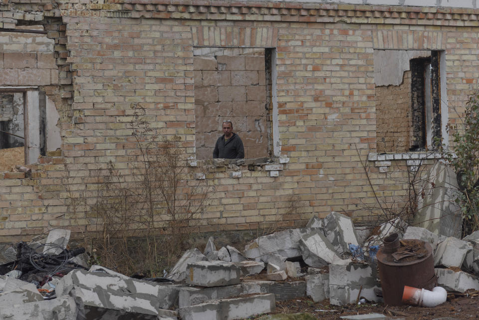 Vadym Zherdetsky is seen in a w indow of his house destroyed by fighting, in the village of Moshun, outside Kyiv, Ukraine, Friday, Nov. 4, 2022. When Russia invaded Ukraine in February, two missiles struck Zherdetsky's home in the tiny village of Moschun on the outskirts of the capital, Kyiv, ripping the roof off and nearly killing four of his family members. (AP Photo/Andrew Kravchenko)