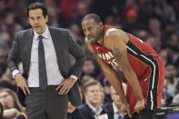 Miami Heat head coach Erik Spoelstra, left, talks with Andre Iguodala in the first half of an NBA basketball game against the Cleveland Cavaliers, Monday, Feb. 24, 2020, in Cleveland. (AP Photo/Tony Dejak)