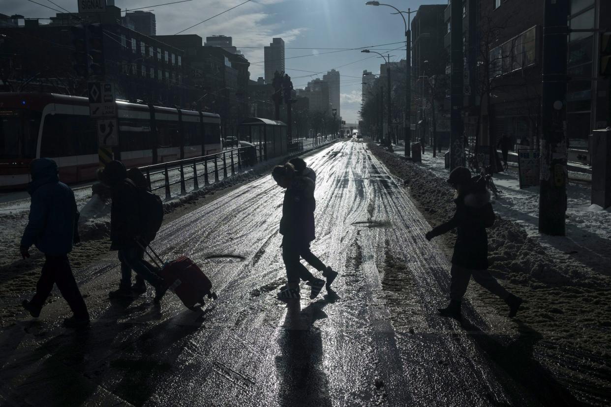 Pedestrians walk across Spadina Avenue on Christmas Day, in Toronto, Monday, December 25, 2017. THE CANADIAN PRESS/Giordano Ciampini