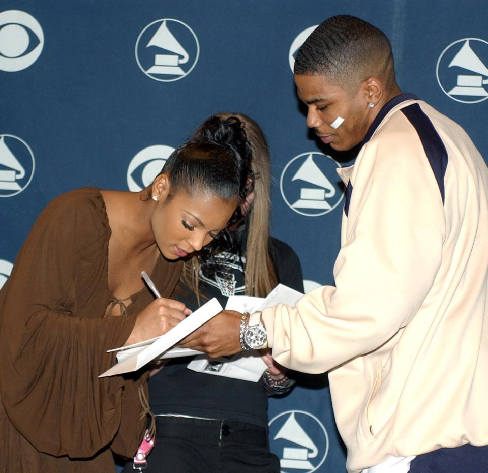 Nelly gets an autograph from fellow Grammy Award nominee Ashanti after they helped read nominations for the 2003 Grammy Awards at Madison Square Garden on Jan. 7, 2003.