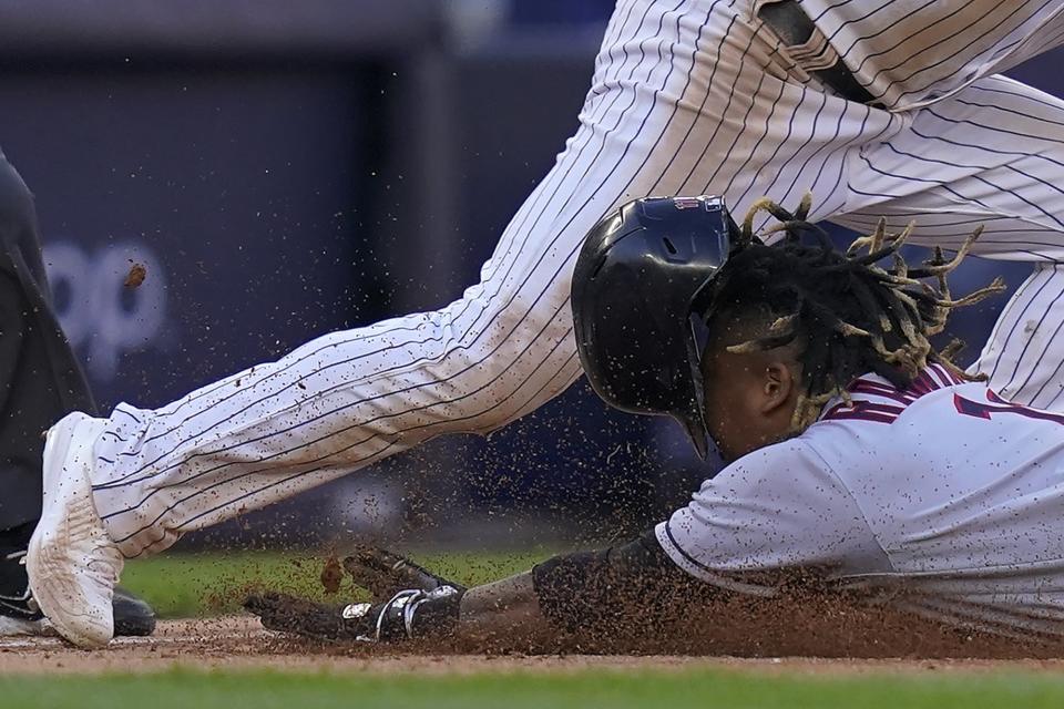 El dominicano José Ramírez, de los Guardianes de Cleveland, se desliza en la antesala frente a Josh Donaldson, de los Yanquis de Nueva York, el 14 de octubre de 2022 (AP Foto/Frank Franklin II)