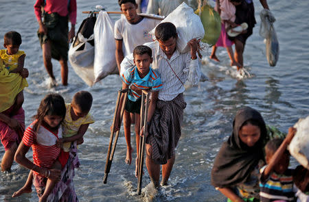Rohingya refugees walk through water after crossing the Bangladesh-Myanmar border, at a port in Teknaf, Bangladesh October 25, 2017. REUTERS/Adnan Abidi