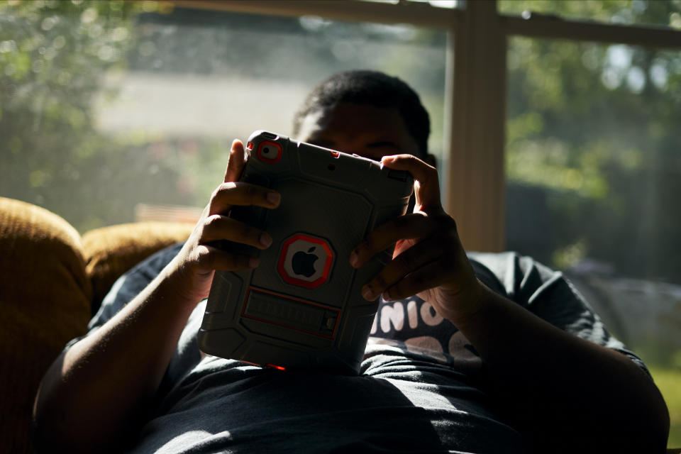 J.H. listens to music on his iPad in the sunroom at his home in Shreveport, Louisiana, on Aug. 25. (Photo: Cooper Neill for HuffPost)