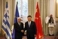 China's President Xi Jinping, centre and his Greek counterpart Prokopis Pavlopoulos, left, shake hands prior to their meeting at the Presidential palace in Athens, Monday, Nov. 11, 2019. Xi Jinping is in Greece on a two-day official visit. (AP Photos/Petros Giannakouris)