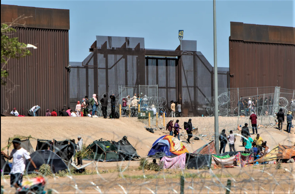 Migrants gather in an informal camp in El Paso, north of the Rio Grande and south of the border wall near Gate 40, on May 5.