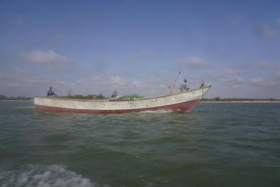 Fishermen sail a pirogue in Saint Louis, Senegal, Sunday, July 16, 2023. Officials and residents say bodies of migrants from capsized boats attempting the dangerous trip from West Africa to Spain are buried in unmarked beach graves. Bodies wash ashore or are found by fishermen at sea, then are buried by authorities. (AP Photo/Sam Mednick)