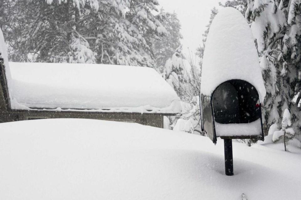 A mailbox and the roof of a home are covered in snow during a storm, Saturday, March 2, 2024, in Truckee, Calif. A powerful blizzard howled Saturday in the Sierra Nevada as the biggest storm of the season shut down a long stretch of Interstate 80 in California and gusty winds and heavy rain hit lower elevations, leaving tens of thousands of homes without power.