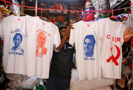 A worker displays T-shirts with images of (L-R) Chief Minister of West Bengal state Mamata Banerjee, Prime Minister Narendra Modi, India's main opposition Congress party Chief Rahul Gandhi and logo of Communist Party of India (Marxist) CPI (M), for sale inside a shop at a market ahead of India's general election, in Kolkata, India, March 26, 2019. REUTERS/Rupak De Chowdhuri