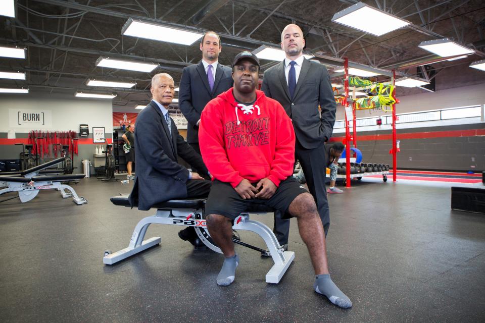 From left:  Mike Fox, seated, owner of Detroit Thrive fitness, is photographed with his civil rights attorneys Gerald Evelyn, Robert Higbee and Peter Alle at his gym in Grosse Pointe Woods, Mich., Thursday, June 6, 2019.  Fox was wrongly arrested a year ago by a Grosse Pointe Woods swat team raid w/K-9 for resembling black bank-robbery suspect, jailed for 48 hours, and cops still call him person of interest although they found real suspect.  Something about an unpaid parking ticket complicates this.