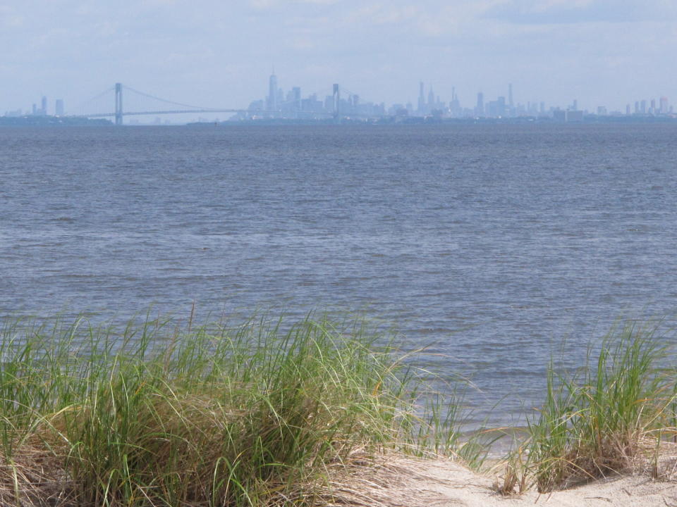 In this June 3, 2019 photo the New York City skyline is in the background of the Raritan Bay as seen from Middletown, N.J. New Jersey environmental officials are due to decide Wednesday, June 5 on key permits for a nearly $1 billion pipeline that would bring natural gas from Pennsylvania through New Jersey, out into Raritan Bay and into the ocean before reaching New York and Long Island. (AP Photo/Wayne Parry)